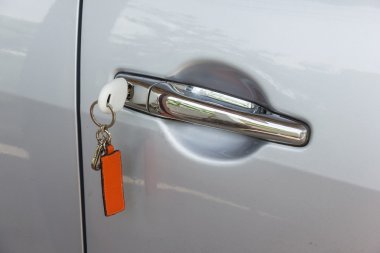Car key and remote control insetered and hanging from door clipart