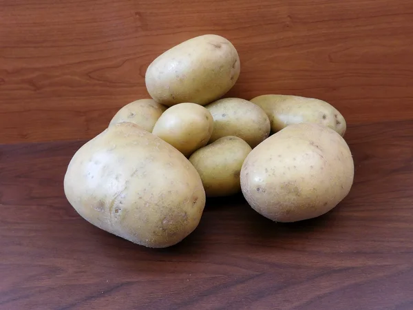 Pommes de terre sur une base en bois dans la cuisine — Photo