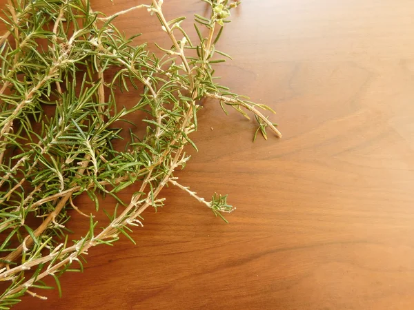 Rosemary in the kitchen on a wooden base — Stock Photo, Image