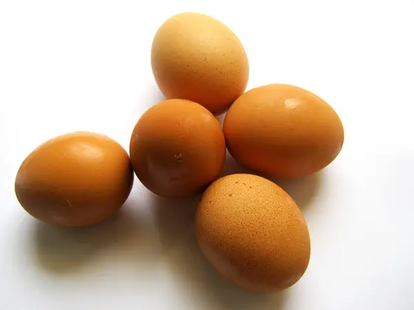Їдять яйця на білому тлі — стокове фото