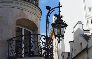 Paris, Fransa. Binanın üzerinde tipik ve klasik metal sokak lambası asılı. Evin duvarında asılı bir fener..