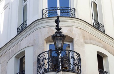 Paris, Fransa. Binanın üzerinde tipik ve klasik metal sokak lambası asılı. Evin duvarında asılı bir fener..