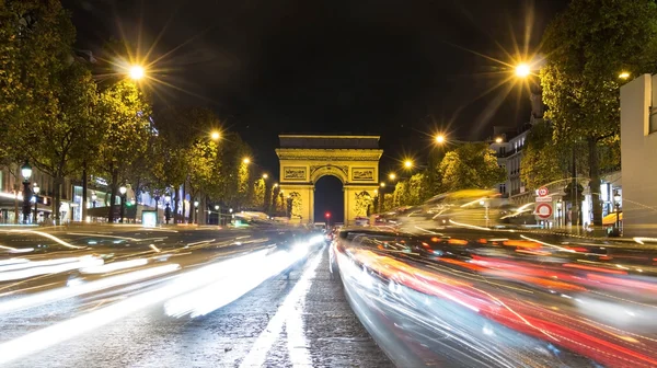 O alto tráfego na avenida Champs-Elysees à noite, Paris, Franc — Fotografia de Stock