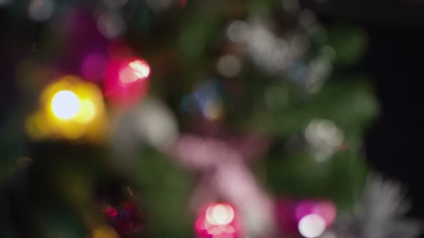 Defocused closeup χριστουγεννιάτικο δέντρο με πολύχρωμη φακούς — Αρχείο Βίντεο