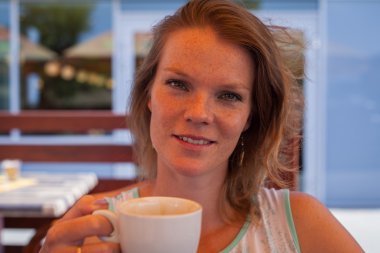 Yaz aylarında bir kafe terasında genç kadın zevk lezzetli bir co