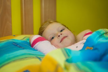 Küçük kız çarşaflarla ahşap bir yatakta uyuyacak