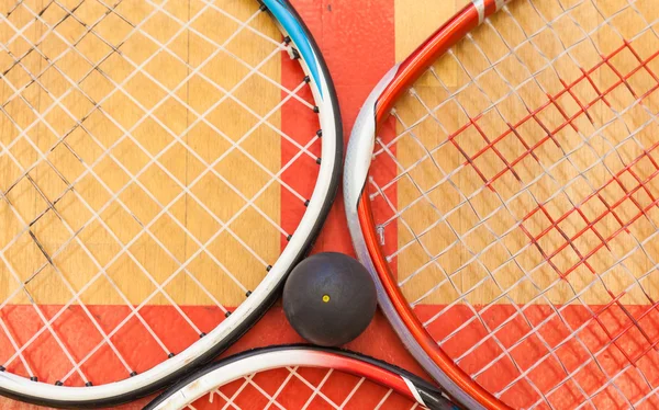 Bola de squash entre raquetes de squash no campo — Fotografia de Stock