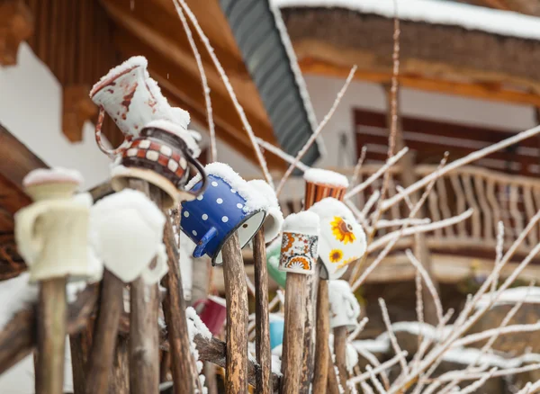 Tazas de colores en una valla de madera en un pueblo maravilla invierno — Foto de Stock