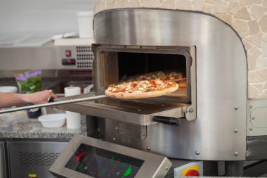 aşçı çeker bir taş fırın fırında pizza yıkanmak