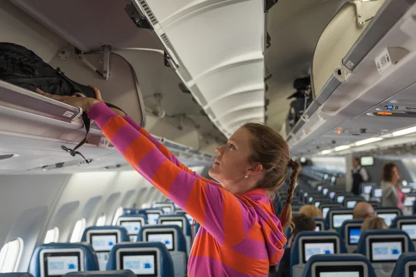 Den unga flickan förlade sitt handbagage in i facket på t — Stockfoto