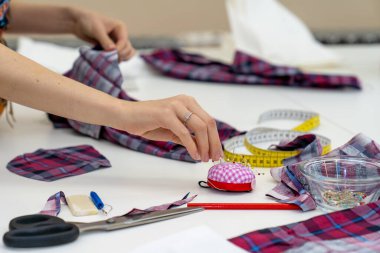 Bir terzi atölyesinde masanın üzerinde çalışma araçları - metre, makas, iğne
