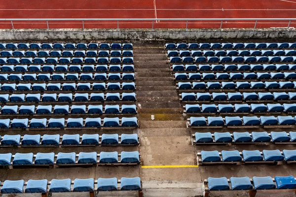 Empty auditorium in athletic stadium, rows of blue chairs — Stock Photo, Image