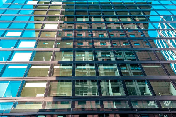 Reflektioner av byggnader i glasväggen på en skyskrapa — Stockfoto