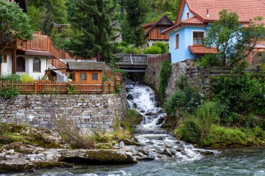 Şelalesi olan bir dağ nehrinin kıyısındaki köy.