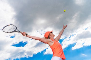 Tenis kortunda genç bir kadın tarafından servis ediliyor.