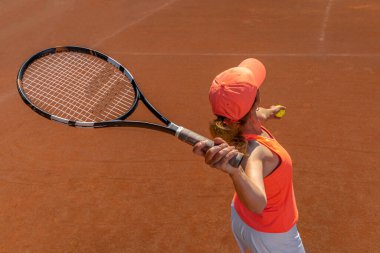 Tenis kortunda genç bir kadın tarafından servis ediliyor. tepeden görünüm