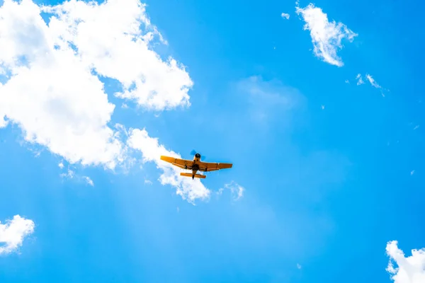 plane with spray on crops in the sky