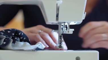 Giysi imalatında dikiş makinesine kumaş dikiyorum.