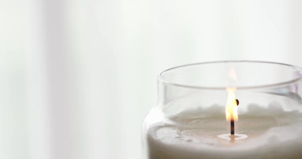 Burning candle in a glass jar. slow motion. copy space — Stock Video