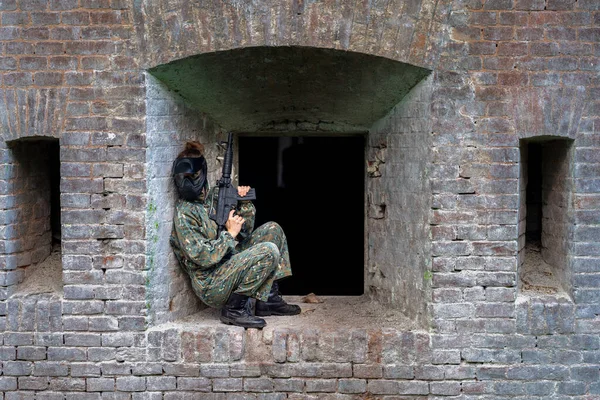 Nő egyenruhában egy fegyvert katonai paintball képzés — Stock Fotó