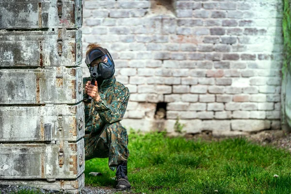 Giovane donna in azione mentre gioca a paintball — Foto Stock