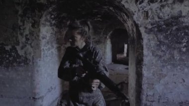 Askeri paintball eğitiminde silahlı bir kadın.