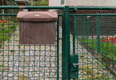 Evin önündeki çitin üzerindeki eski posta kutusu.