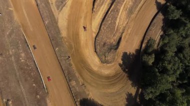 Güneşli bir gün yarışında, havada uçan küçük kartların yarış pistinde sürüklenen ve sürüklenen hava aracı görüntüleri. Dar virajlarda sürüklenen ve geçen bazı arabalar.