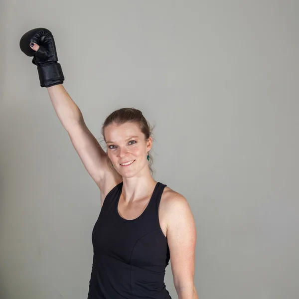 Una joven mujer se inclina de las manos del saco de boxeo negro — Foto de Stock