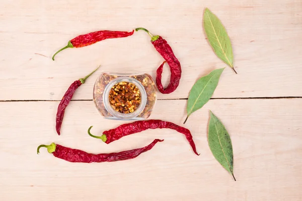 Pimientos rojos y hoja de laurel sobre madera — Foto de Stock