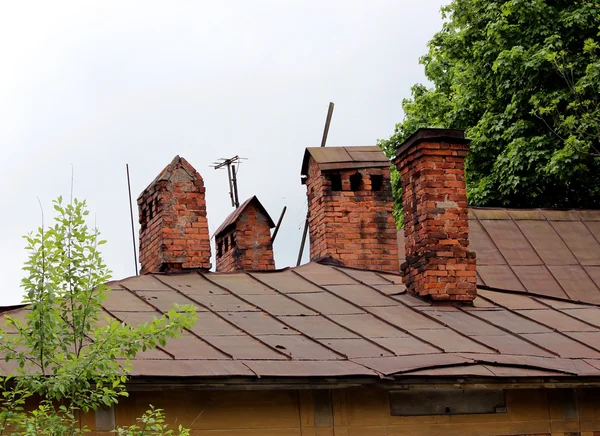 Old ethnic brick chimneyes on roof — Stock Photo, Image