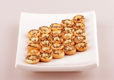 Mini halka şeklinde cracknels beyaz plaka üzerinde haşhaş ile kümesi