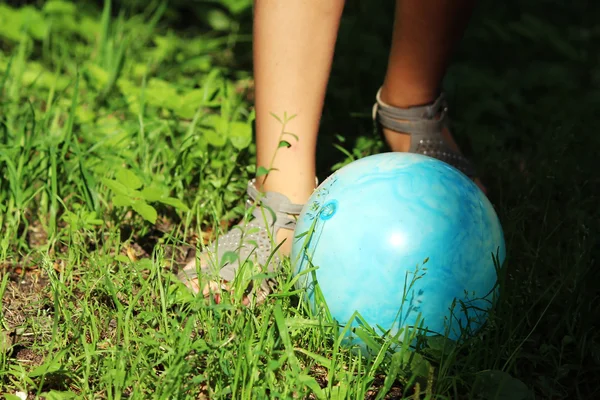 穿着凉鞋的少女在公园草地上踢蓝球 — 图库照片