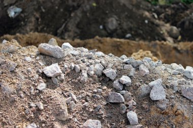 Granit taşlar, kum ve toprak, yol yapımına hazırlanan turbaların çıkarılması sırasında kazılmış..