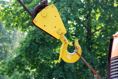 Yeşil arka planda sarı vinç kancası.