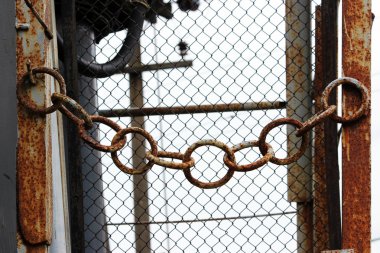 Elektrik santralinin girişinde paslı metal zincir var.