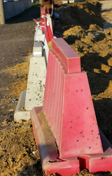 Kırmızı ve beyaz plastik bariyerler yolu kapatıyor.