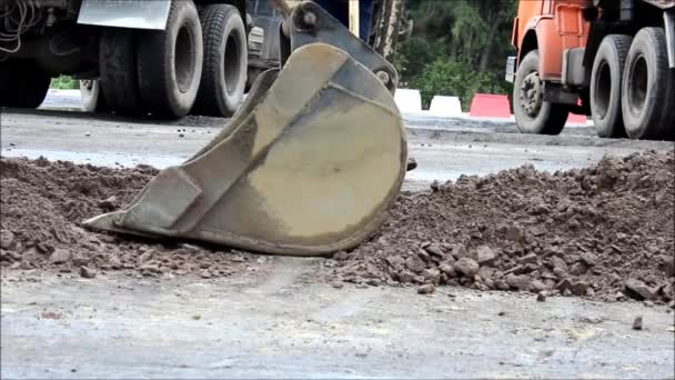 道路部の修理だ 作業員はバケツ付きトラクターを使用して小さな領域を修復しています アスファルトが除去され 砂利が埋め戻され タンプされます 報告書 — ストック動画