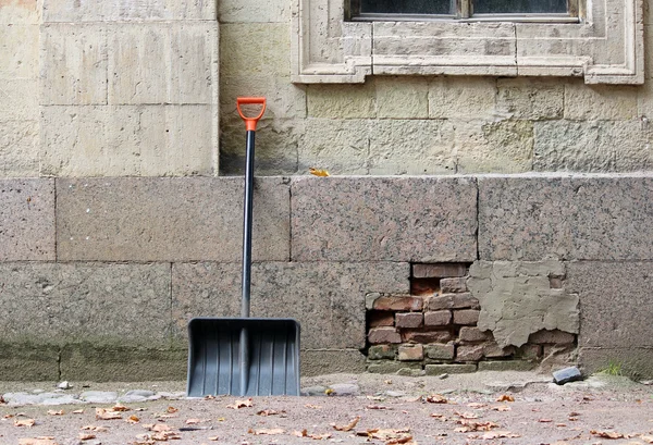 Neue Schwarze Schaufel Mit Orangefarbenem Griff Lehnt Der Mauer Des — Stockfoto