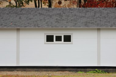 Beyaz duvar desenli ev, kara kutu, arka planda esnek kahverengi fayanslar sonbahar ormanlarının çok renkli yaprakları.