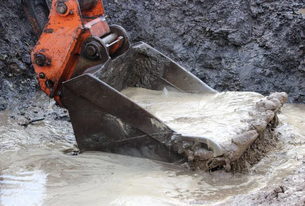 Excavator tracks in the water. repair and expansion of a road in the north of gatchina, russia. reportage shooting. — Stock Photo, Image