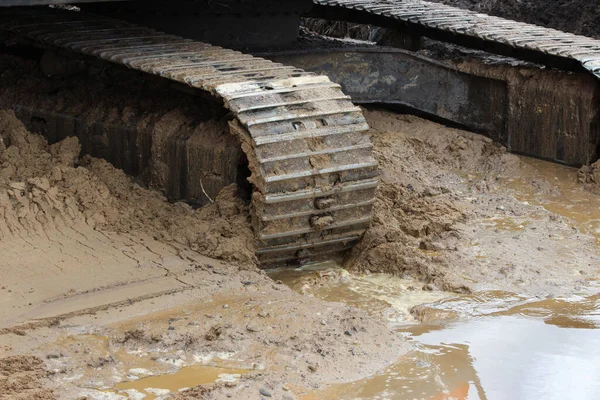 Excavator tracks in the water. repair and expansion of a road in the north of gatchina, russia. reportage shooting. — Stock Photo, Image