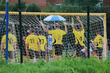 Sarı tişörtlü futbolcular ortak bir fotoğraf için kapıda duruyorlar. arka plan