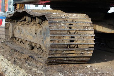 Büyük bir kazıcının tırtılları otoyolun onarım ve genişletildiği alana yakın çekim yapıyor.