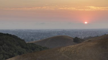 Hazy sunset over Hayward via Hayward Hills in Alameda County, California, USA. clipart