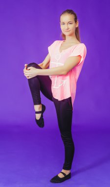 woman in red doing exercises while standing on a blue background in the fitness room