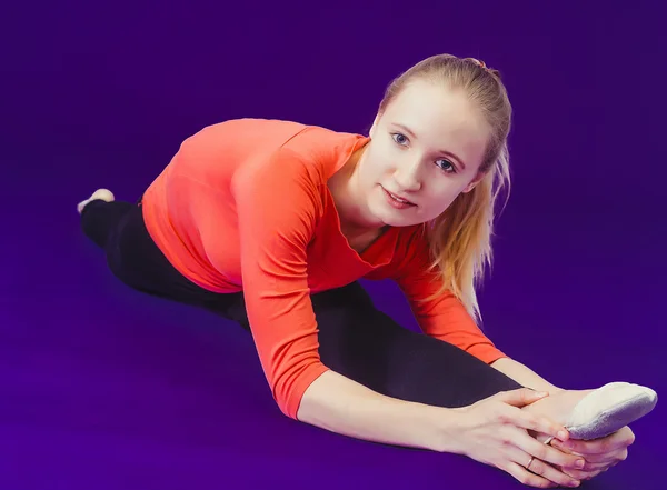 女人在做伸展练习在健身房地板上 — 图库照片
