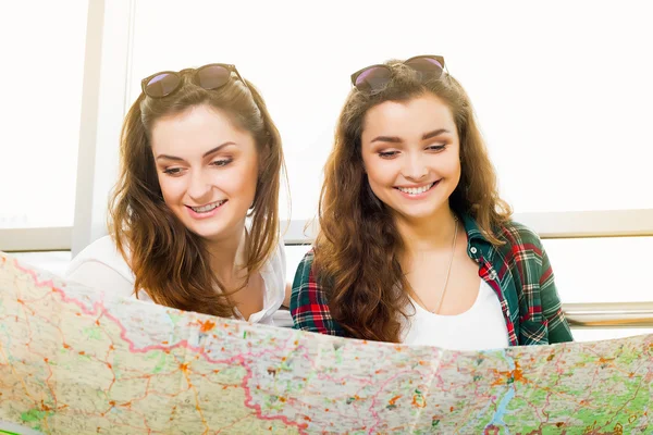 Dvě mladá černovlasá dívka při pohledu na mapu — Stock fotografie