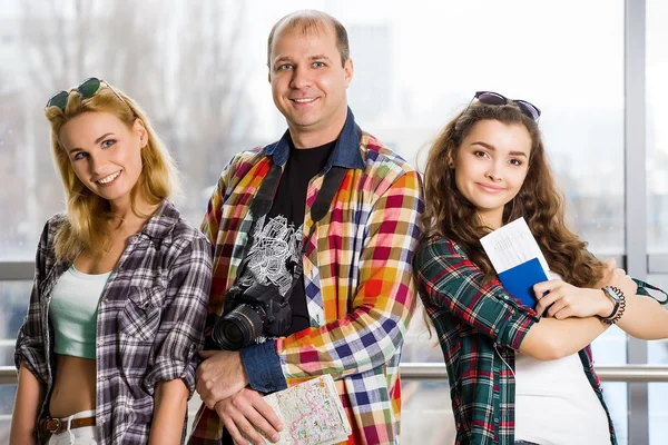 Uomo e due donne in piedi nell'atrio della stazione e l'aeroporto guardando nella telecamera . — Foto Stock