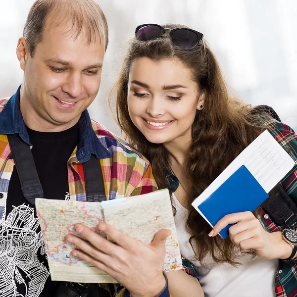 man and a woman holding a passport .Look at the map, direction of study. Europeans. Gathered in a guided tour.Honeymoon